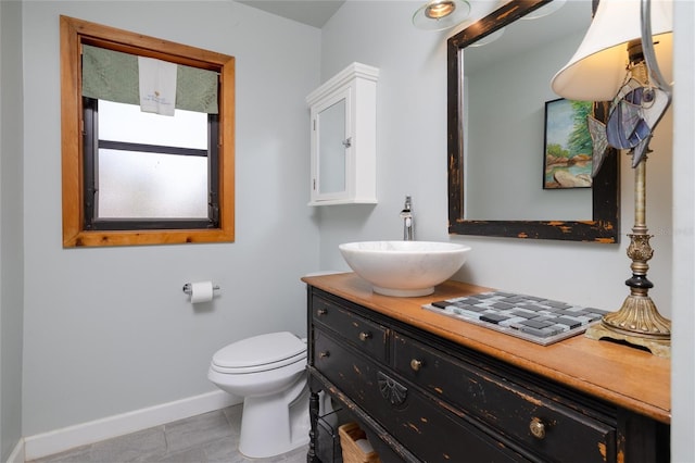 825 E 23rd Ave, New Smyrna Beach, FL 32169 - bathroom featuring baseboards, tile patterned flooring, vanity, and toilet
