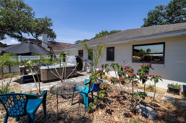 825 E 23rd Ave, New Smyrna Beach, FL 32169 - rear view of property with a patio, a shingled roof, and a hot tub