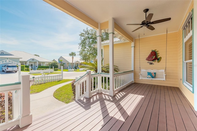 2815 Bay Side Dr, New Smyrna Beach, FL 32168 - wooden deck with covered porch, a ceiling fan, and a residential view