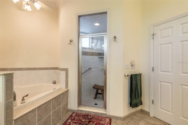 2815 Bay Side Dr, New Smyrna Beach, FL 32168 - full bathroom featuring tile patterned flooring, ceiling fan, a bath, baseboards, and a stall shower