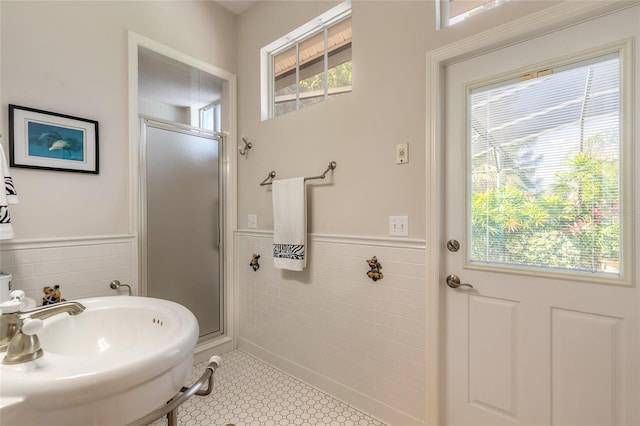 2815 Bay Side Dr, New Smyrna Beach, FL 32168 - bathroom with tile walls, a wainscoted wall, a shower stall, and a sink