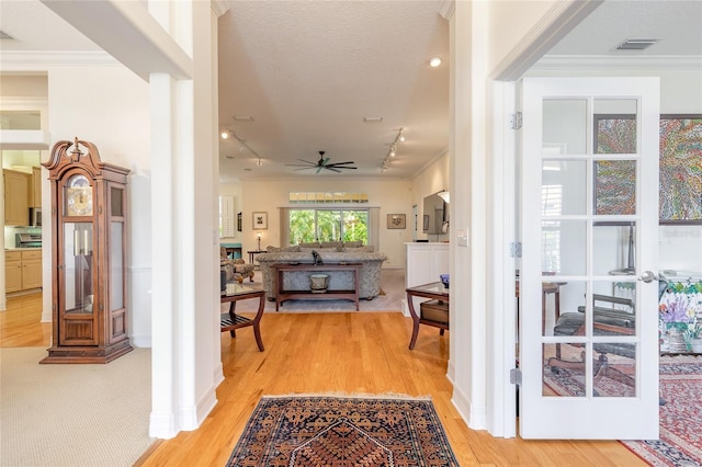2815 Bay Side Dr, New Smyrna Beach, FL 32168 - foyer featuring crown molding, visible vents, light wood-style floors, rail lighting, and a ceiling fan
