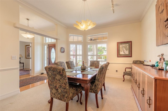 2815 Bay Side Dr, New Smyrna Beach, FL 32168 - dining space featuring light colored carpet, ornamental molding, and baseboards