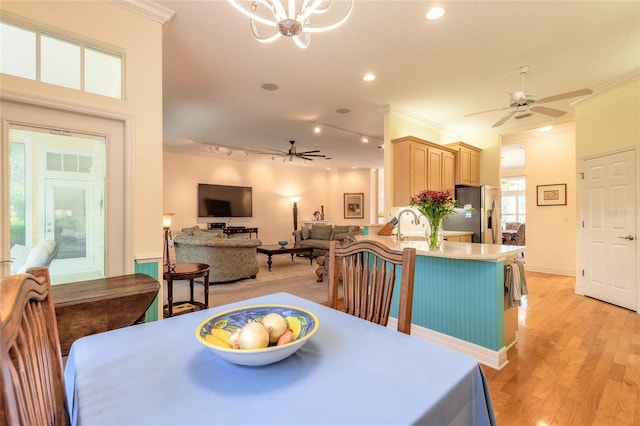 2815 Bay Side Dr, New Smyrna Beach, FL 32168 - dining area featuring light wood-style floors, ornamental molding, and ceiling fan with notable chandelier