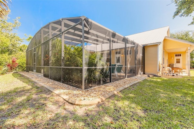 2815 Bay Side Dr, New Smyrna Beach, FL 32168 - rear view of property featuring glass enclosure, metal roof, and a yard