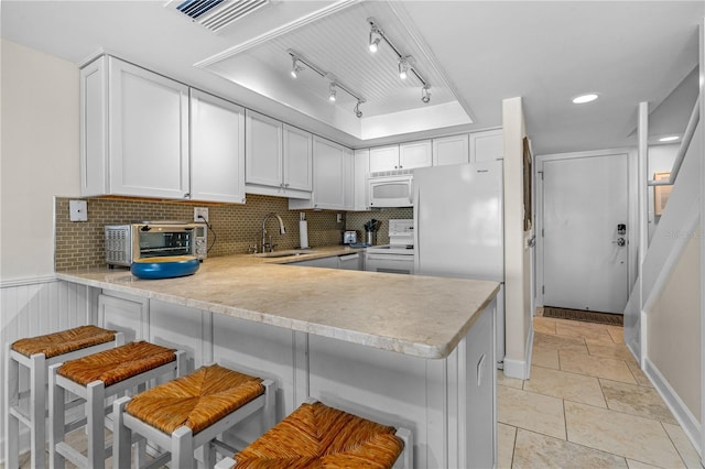 4841 Saxon Dr Unit C201, New Smyrna Beach, FL 32169 - kitchen with a peninsula, a toaster, white appliances, light countertops, and a sink
