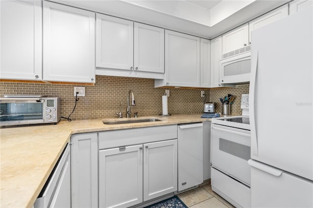 4841 Saxon Dr Unit C201, New Smyrna Beach, FL 32169 - kitchen featuring decorative backsplash, a sink, light countertops, white cabinets, and white appliances