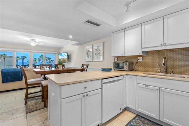 4841 Saxon Dr Unit C201, New Smyrna Beach, FL 32169 - kitchen featuring a sink, dishwasher, a peninsula, a ceiling fan, and visible vents
