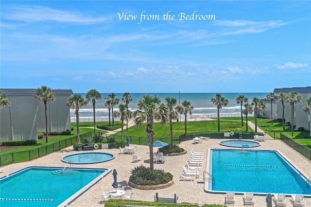 4841 Saxon Dr Unit C201, New Smyrna Beach, FL 32169 - pool featuring fence, a patio, a water view, and a community hot tub