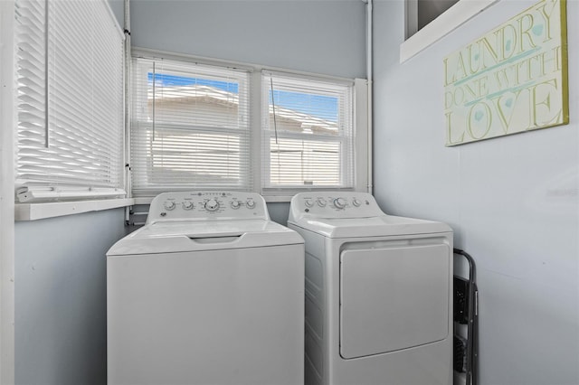 laundry room with laundry area, washer and clothes dryer, and a wealth of natural light