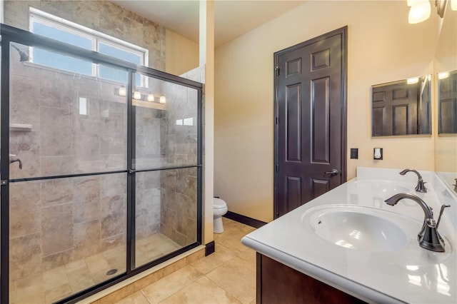 bathroom with a sink, a stall shower, toilet, and double vanity