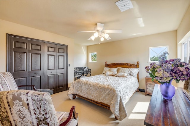carpeted bedroom featuring a ceiling fan and visible vents