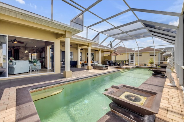outdoor pool with ceiling fan, a patio area, a lanai, and an outdoor living space with a fire pit