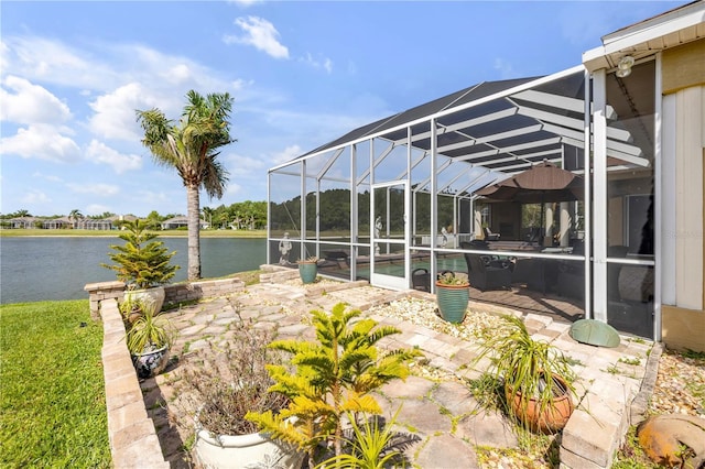 view of patio / terrace featuring a water view, an outdoor pool, and a lanai