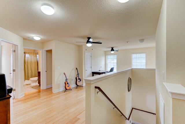 1703 Frogs Leap Ct, Port Orange, FL 32128 - kitchen featuring a textured ceiling, light wood-style floors, baseboards, a peninsula, and a ceiling fan