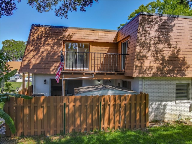 95 Moonstone Ct, Port Orange, FL 32129 - rear view of house featuring fence, a balcony, stucco siding, and brick siding