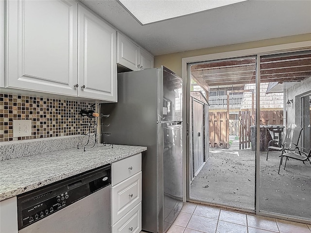 95 Moonstone Ct, Port Orange, FL 32129 - kitchen with stainless steel dishwasher, white cabinetry, decorative backsplash, and plenty of natural light