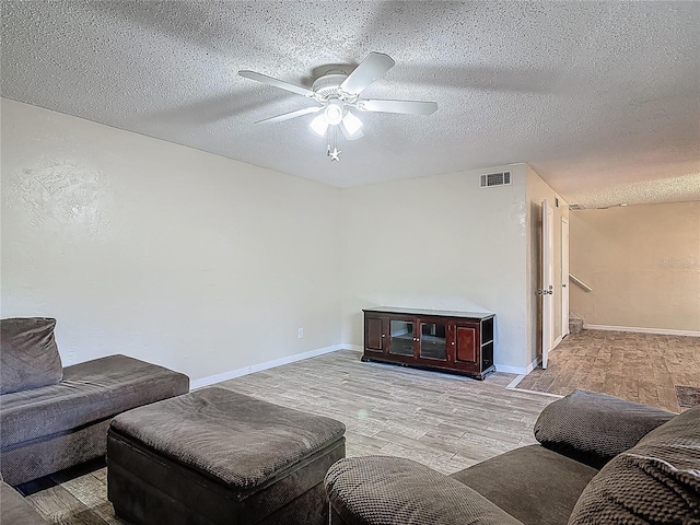 95 Moonstone Ct, Port Orange, FL 32129 - living area featuring light wood-style flooring, ceiling fan, a textured ceiling, and baseboards