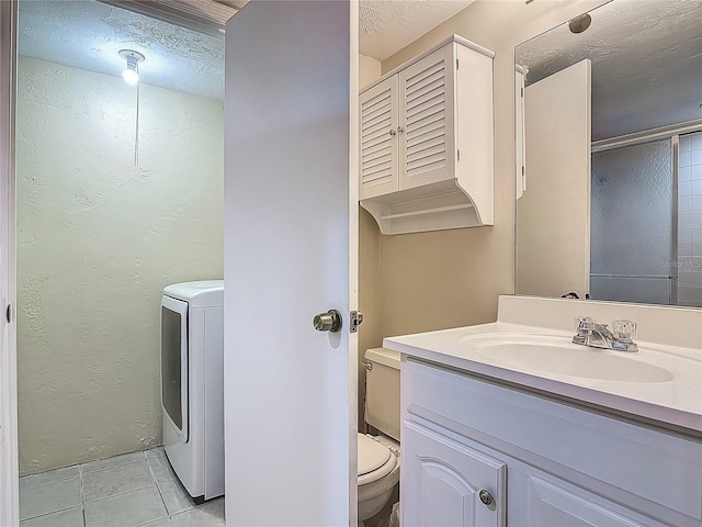 95 Moonstone Ct, Port Orange, FL 32129 - bathroom featuring washer / clothes dryer, toilet, tile patterned flooring, vanity, and a textured ceiling