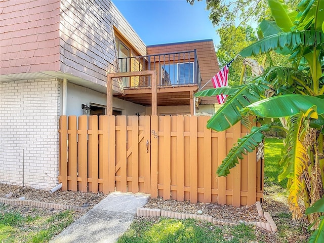 95 Moonstone Ct, Port Orange, FL 32129 - view of home's exterior with brick siding, a balcony, mansard roof, and fence
