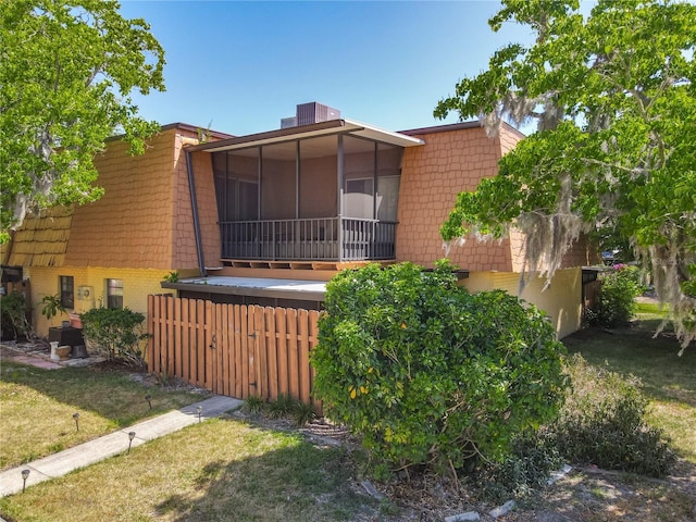 95 Moonstone Ct, Port Orange, FL 32129 - view of side of property with a sunroom, mansard roof, brick siding, and a yard
