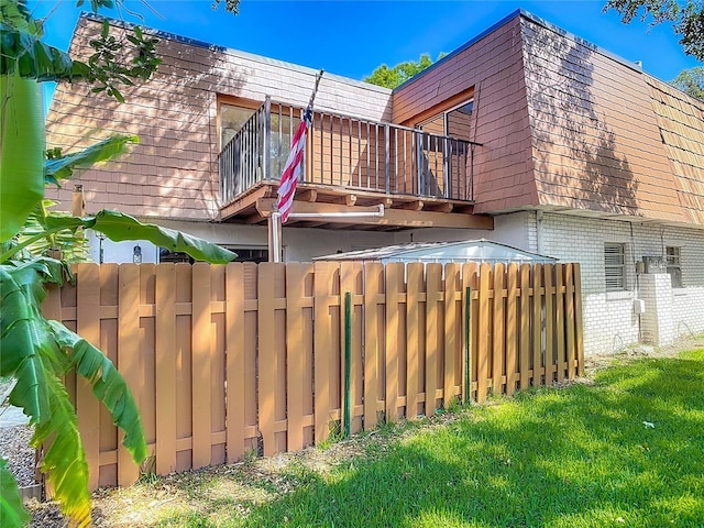95 Moonstone Ct, Port Orange, FL 32129 - back of property featuring a balcony, brick siding, and mansard roof