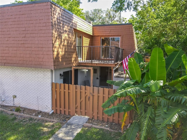 95 Moonstone Ct, Port Orange, FL 32129 - rear view of house featuring a balcony, mansard roof, and fence