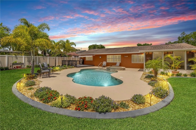 2548 E Compton St, Orlando, FL 32806 - pool at dusk featuring fence, a patio, a yard, and a pool with connected hot tub