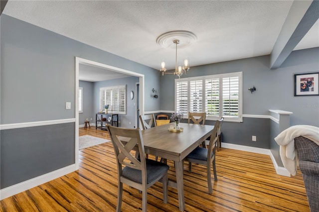 2548 E Compton St, Orlando, FL 32806 - dining space featuring baseboards, wood finished floors, a healthy amount of sunlight, and an inviting chandelier