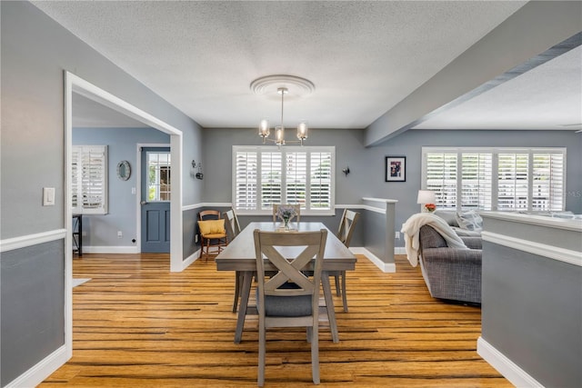 2548 E Compton St, Orlando, FL 32806 - dining area with a textured ceiling, light wood-style flooring, a chandelier, and a wealth of natural light
