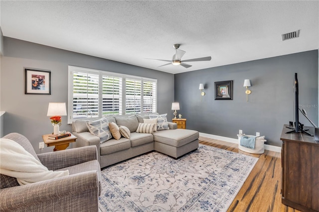 2548 E Compton St, Orlando, FL 32806 - living area with a textured ceiling, a ceiling fan, baseboards, wood finished floors, and visible vents