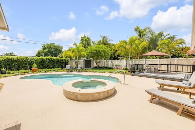 2548 E Compton St, Orlando, FL 32806 - view of swimming pool with an outdoor structure, a fenced backyard, a storage unit, a patio area, and a pool with connected hot tub