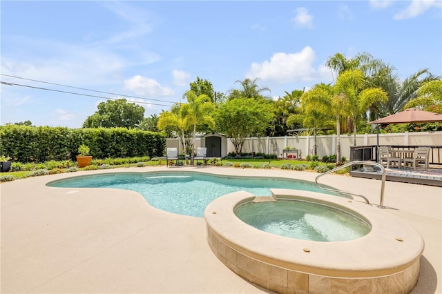 2548 E Compton St, Orlando, FL 32806 - view of swimming pool with a patio, a fenced backyard, a pool with connected hot tub, and a storage shed