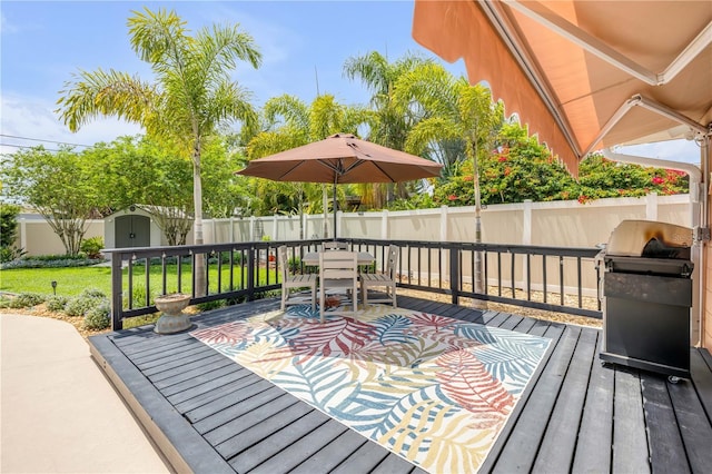 2548 E Compton St, Orlando, FL 32806 - wooden terrace with outdoor dining space, a storage shed, a fenced backyard, an outbuilding, and a yard