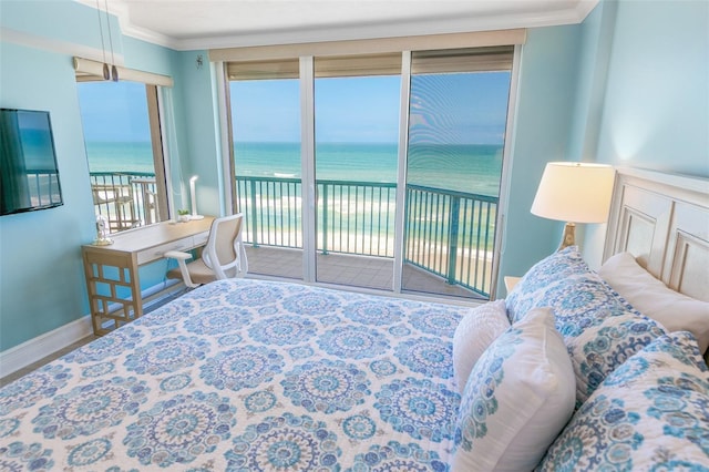 bedroom featuring a water view, ornamental molding, baseboards, and access to exterior