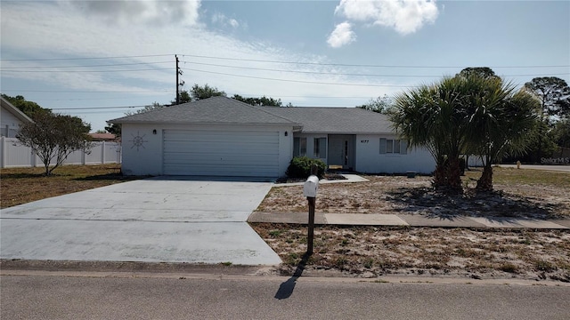 ranch-style home featuring fence, driveway, and a garage