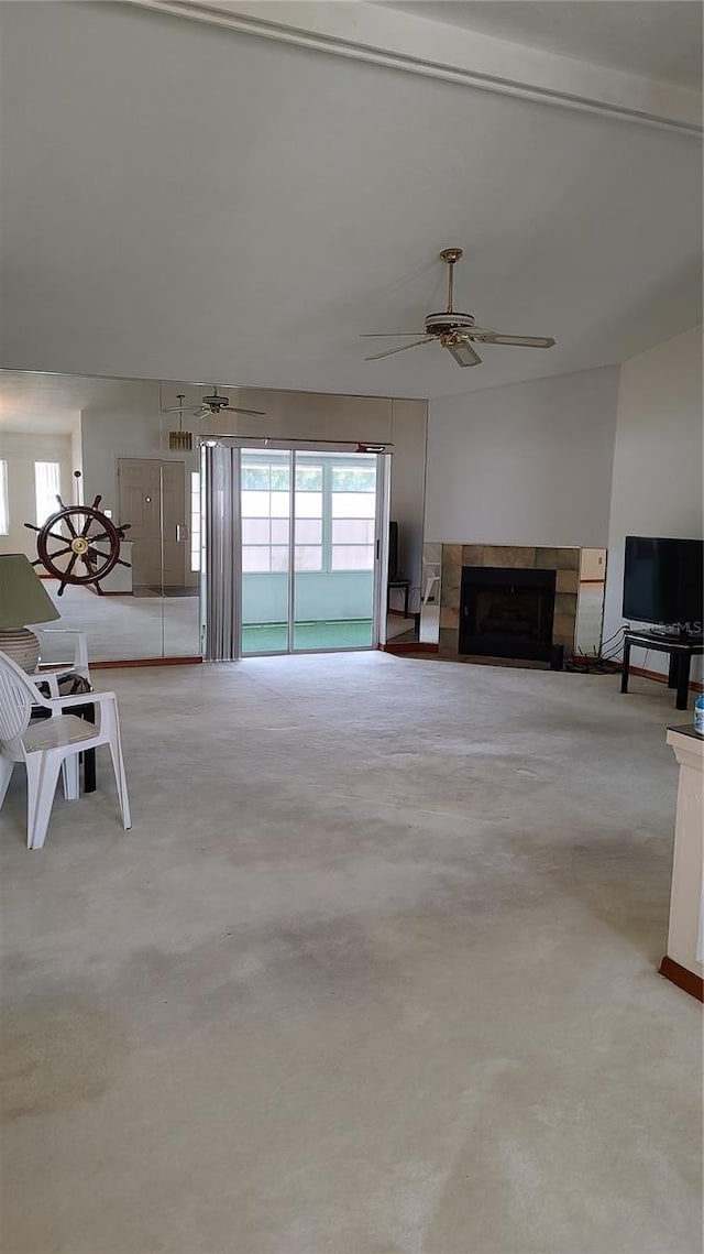unfurnished living room featuring ceiling fan and a fireplace