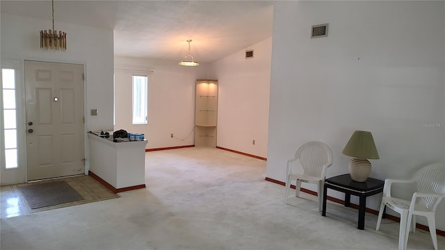 entryway featuring visible vents, carpet, baseboards, and vaulted ceiling