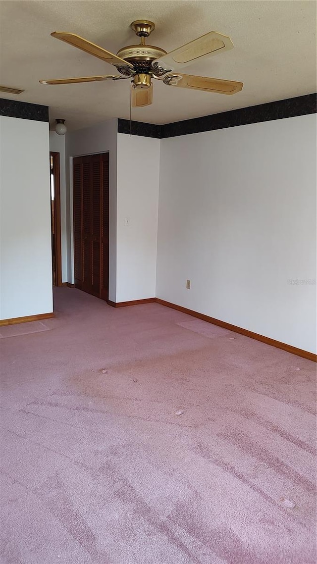 spare room featuring baseboards, carpet flooring, and ceiling fan