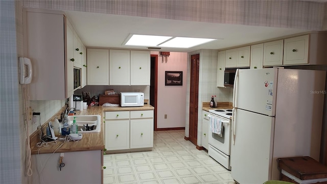 1077 Willow Wood Dr, Port Orange, FL 32129 - kitchen with white appliances, light floors, backsplash, butcher block countertops, and white cabinetry