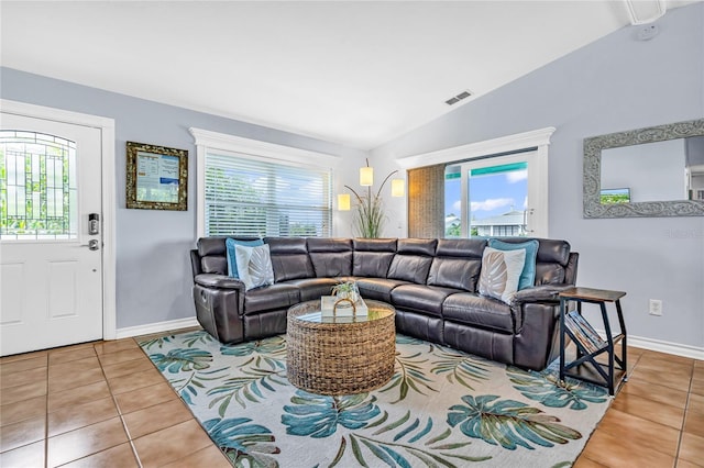 living room featuring tile patterned floors, lofted ceiling, and a wealth of natural light