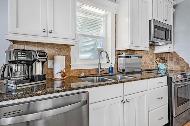 kitchen featuring stainless steel appliances, white cabinetry, and a sink