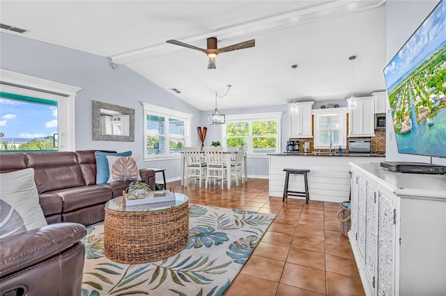 living area featuring ceiling fan, visible vents, tile patterned flooring, baseboards, and vaulted ceiling with beams