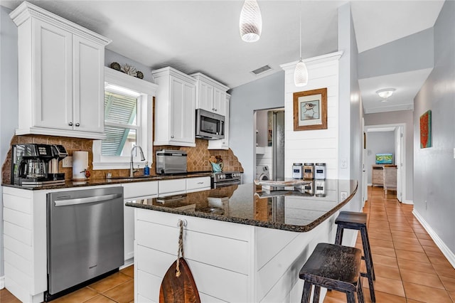 kitchen with visible vents, tasteful backsplash, a sink, appliances with stainless steel finishes, and light tile patterned floors