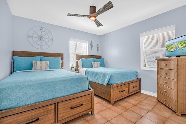bedroom featuring a ceiling fan, baseboards, and light tile patterned floors
