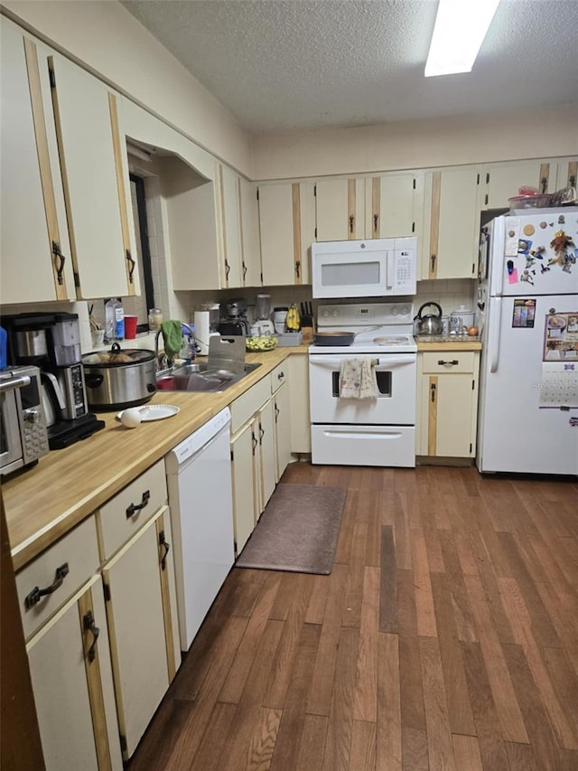 kitchen featuring dark wood-style flooring, white appliances, light countertops, a textured ceiling, and a sink