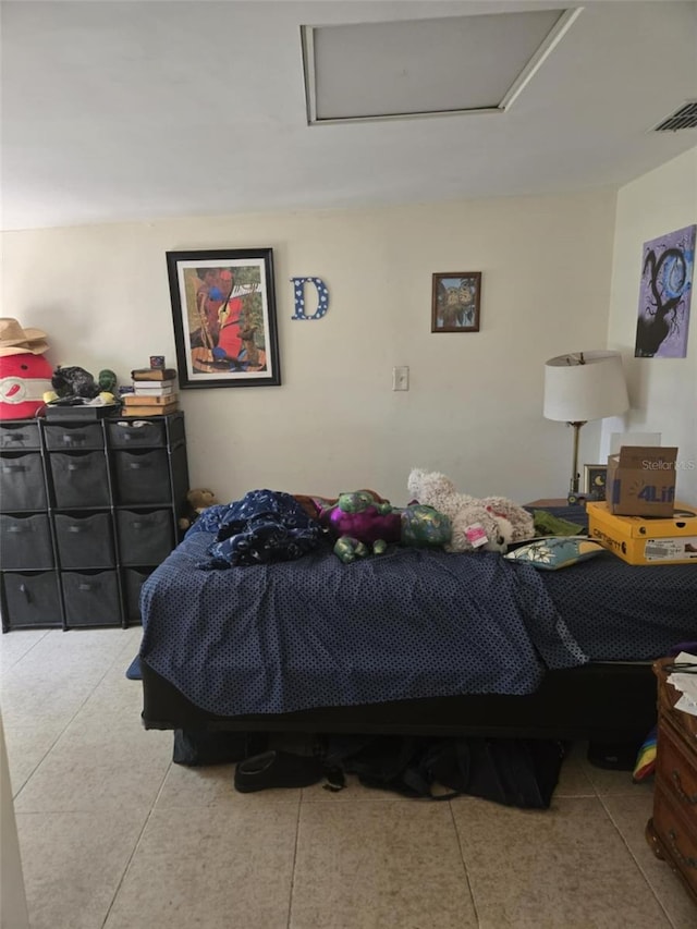 bedroom with visible vents, attic access, and tile patterned flooring