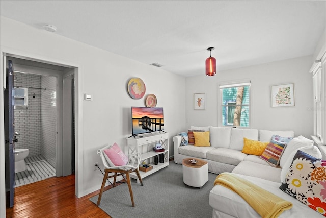living room with baseboards, wood finished floors, and visible vents