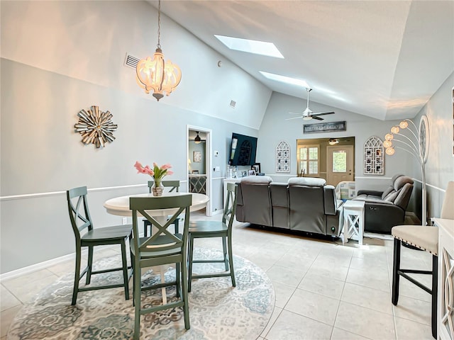 dining space with high vaulted ceiling, ceiling fan with notable chandelier, light tile patterned floors, a skylight, and visible vents