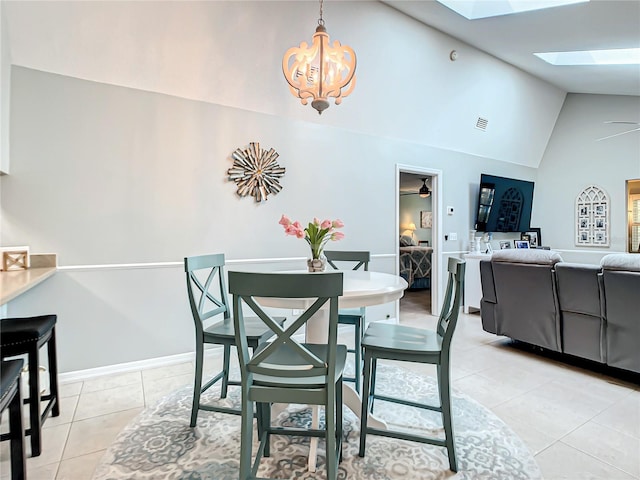 dining area featuring visible vents, a skylight, light tile patterned floors, high vaulted ceiling, and an inviting chandelier